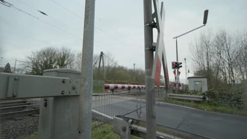 O trem de alta velocidade passa por uma travessia ferroviária rural em um dia nublado