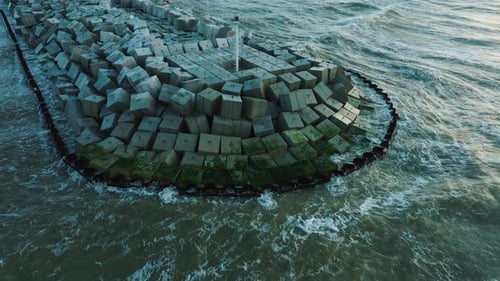 Vista aérea del establecimiento del muelle de piedra protector con bloques de hormigón y rocas en la costa del mar Báltico