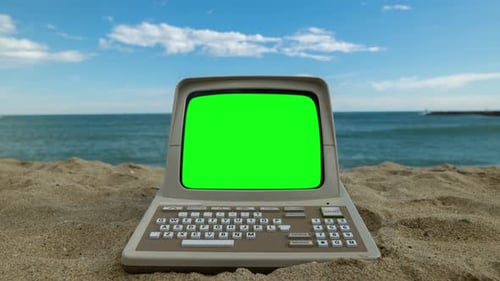 Computer am Meer mit grünem Bildschirm