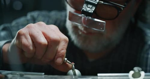 Slow motion of experienced goldsmith working on a handmade jewelry ring with precious diamond ston