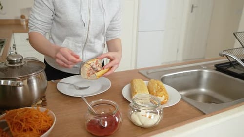 Person Making Filled Sandwiches in Bright Kitchen