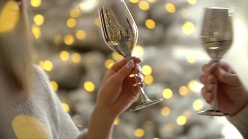 Homem e mulher tilintam óculos durante a celebração da festa de ano novo