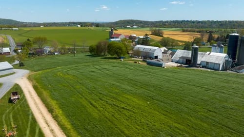 Rural farms in USA. Aerial hyperlapse revealing barns, silos, and houses in American countryside dur