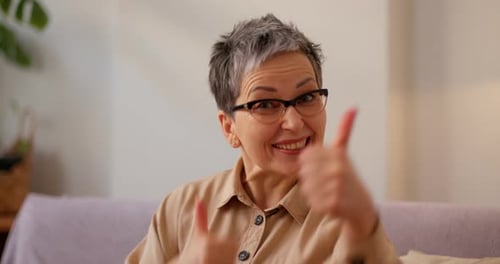 Smiling Woman Gives Enthusiastic Thumbs Up