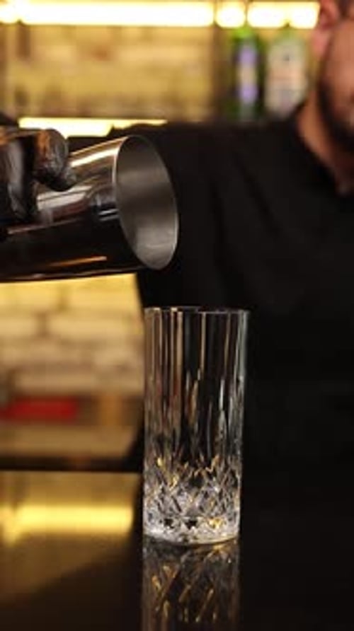 the bartender at the bar prepares alcoholic cocktails