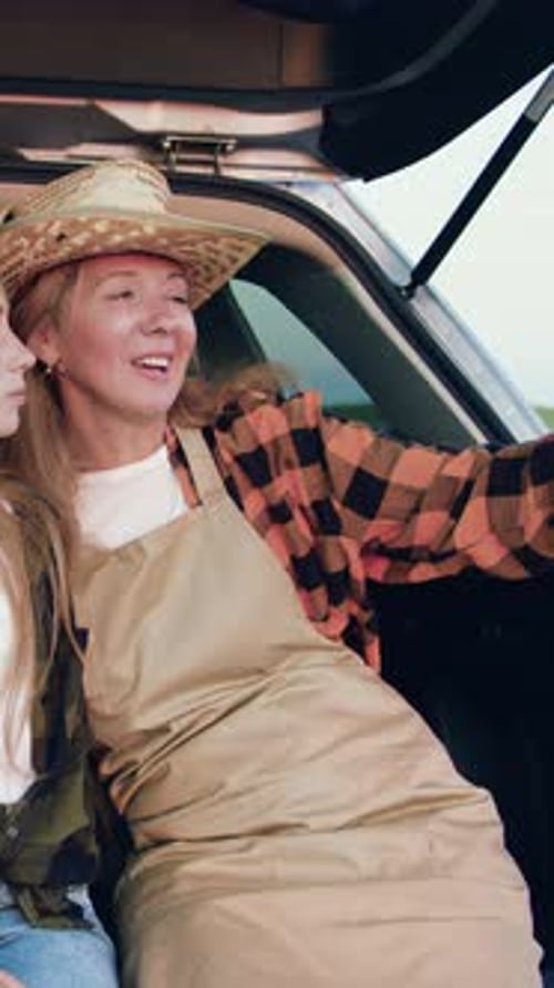 Mother and Daughter Smiling in Car Trunk