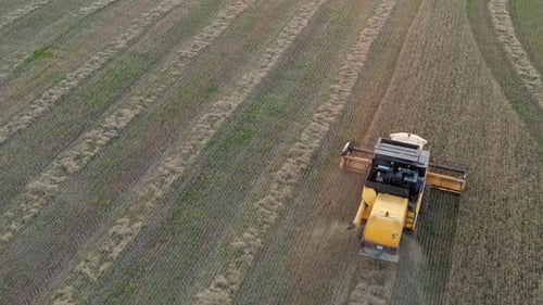 Aerial Following Over Harvester Moving Along Field