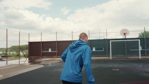 Athletic Man Kicks Soccer Ball on Outdoor Court