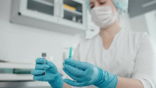 Hospital nurse taking blood sample for coronavirus antibodies testing in modern laboratory
