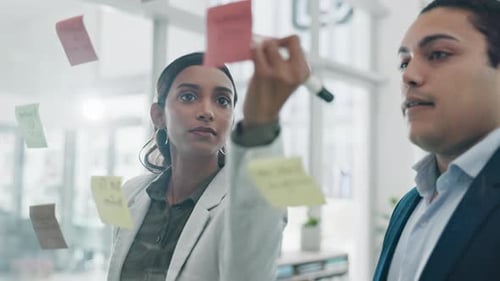 Glass wall, teamwork and business people planning, writing and schedule in office