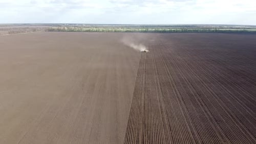 Tractor with yellow seeder working on the field in Ukraine OA Lexa