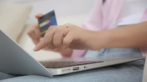 Woman enters credit card information into laptop
