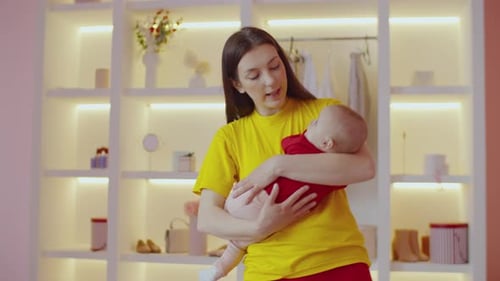 Young Woman Holding Baby in Bright Walk-in Wardrobe