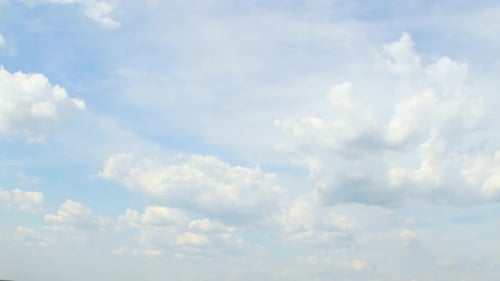 Slowly moving white clouds against a blue sky.