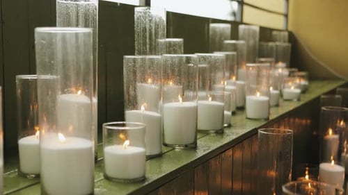 Lit Candles in Glass Cylinders at Wedding