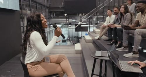 Woman Speaking at Corporate Event to Diverse Group