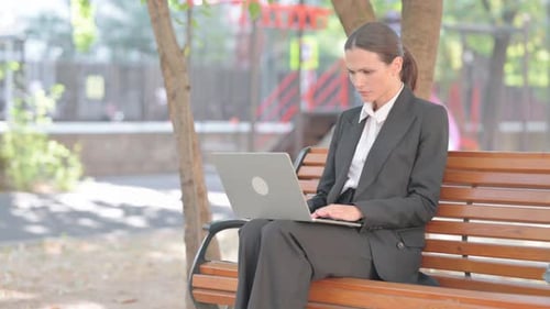 Business Woman Shocked by Loss on Laptop Outdoor