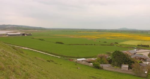 Countryside Landscape Of Large Field With Green Grasses And House In Somerset, England. wide shot