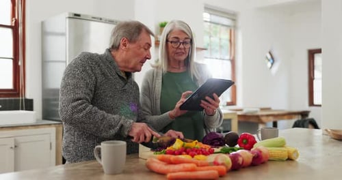 Senior Couple Cooking with Tablet in Kitchen