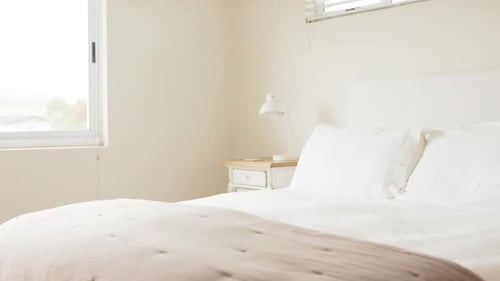 General view of bedroom with pillows on double bed, slow motion