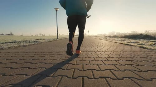 Man Runs on Brick Path on Cold Morning