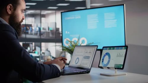 Man Analyzing Data on Laptop and Tablet