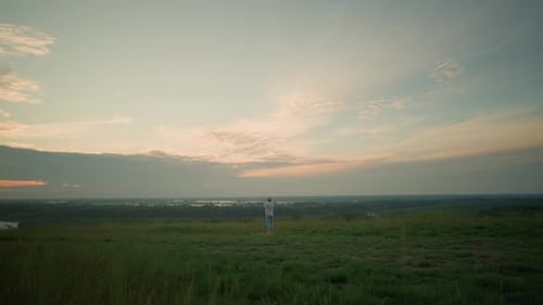 Distant Contemplation Man in Tranquil Landscape By Lake at Sunset