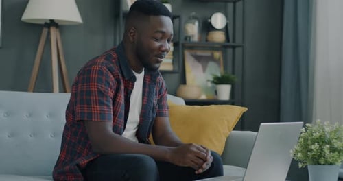 Man Video Conferencing on Laptop at Home