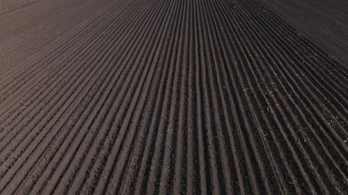 Aerial View of Freshly Plowed Dark Soil Agricultural Field