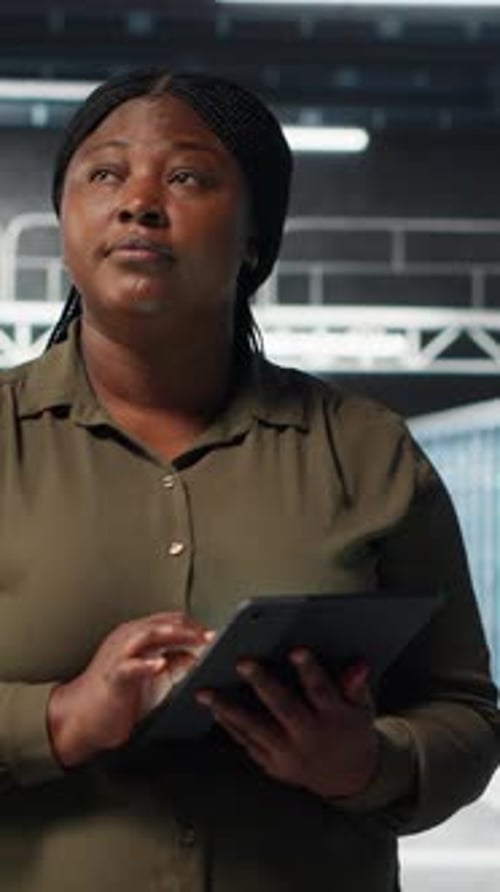 Vertical Video Admin Walking in Data Center Using Tablet to Manage Software Updates