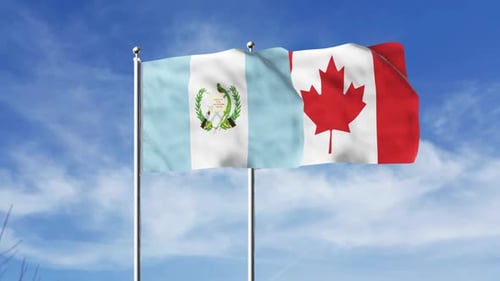 Guatemala and Canada Flags Waving Under Blue Sky
