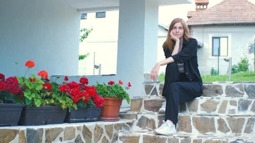 Alone Beautiful Young Woman Enjoying Beautiful Flowers in Her Garden Near Her House