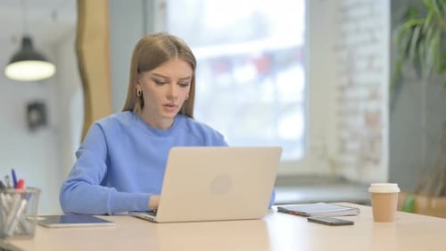 Woman Coughing While Using Laptop at Work