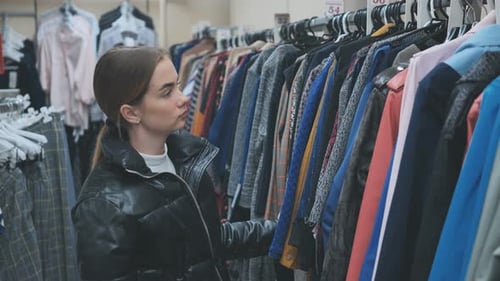 A Young Girl Choosing and Looking at Clothes in the Store