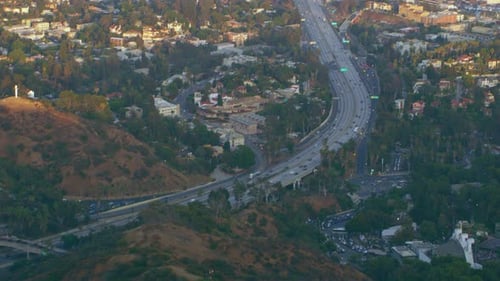 Los Angeles California aerial view of highway traffic and sprawling suburbs in sunlight