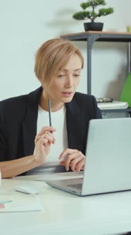 Woman Talking on Video Call at Desk