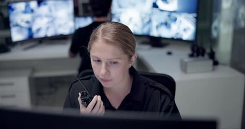 Woman Communicates Over Walkie Talkie in Security Office