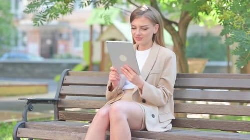 Woman Using Tablet on Park Bench