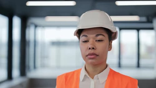 Confident Female Engineer in Hard Hat and Vest at Office Building