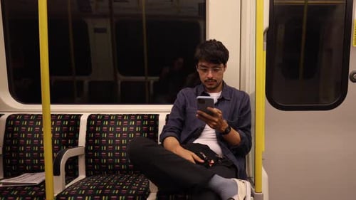 man looking at his smart phone on the London Underground