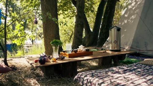A wooden stand with bowls filled with water and cups of tea stands on table among greens vegetables