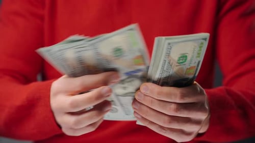 Hands Counting Stacks of Hundred Dollar Bills
