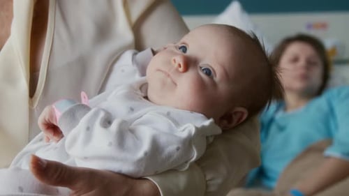 Precious Newborn Infant Cradled in Hospital Room