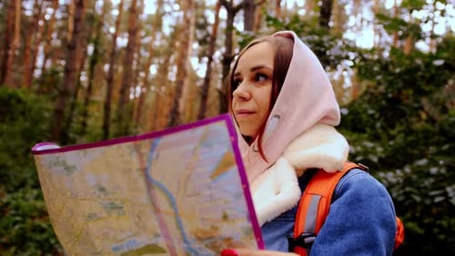 Cute Girl Reading Map in Forest
