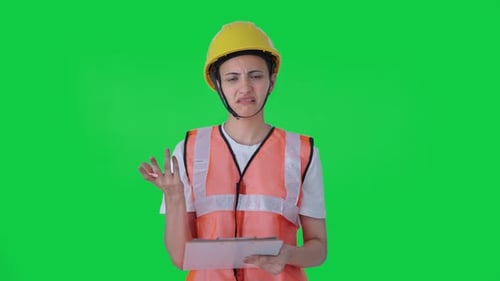 Confused Indian construction worker taking notes of building Green screen