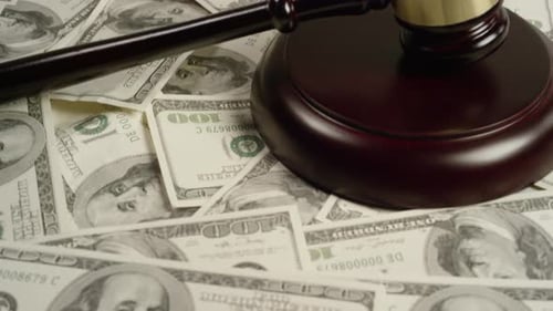 Gavel Lying on Pile of Hundred Dollar Bills