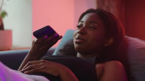 Woman Relaxing on Couch, Using Smartphone, Indoors