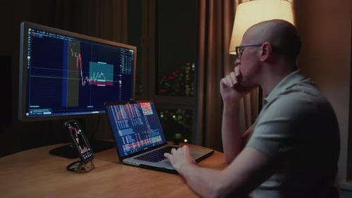 Man Stock Trader in Home Office Male Analyzes Terminal Trades Stocks on Crypto Market Quotes From