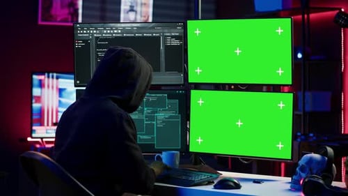 Hacker Developing Spyware Software on Green Screen Computer to Steal Data