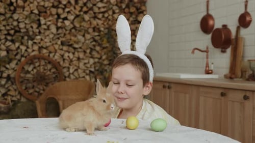 Boy with Bunny Ears Petting a Rabbit Indoors